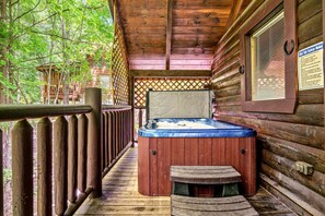 A hot tub on a wooden deck with a wooden cabin structure in the background. - Mountain Dream (Sevierville)