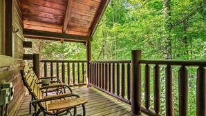 A wooden deck with benches and a railing overlooking a forest. - Mountain Dream (Sevierville)