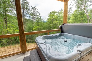 A hot tub with a wooden deck and a view of a forest. - Away From It All (Sevierville)