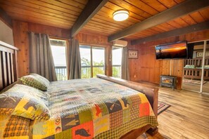 A wooden cabin room with a bed, a television, and a fireplace. - The Top (Sevierville)