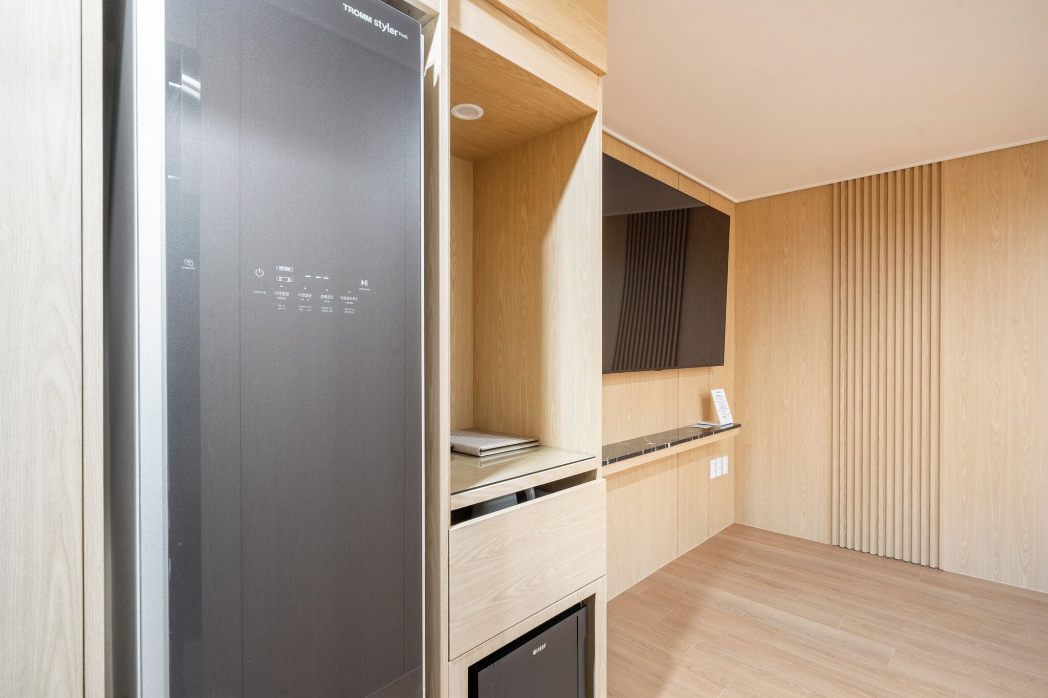 Une cuisine moderne équipée d’un réfrigérateur encastré, d’un four à micro-ondes et d’un petit plan de travail.
