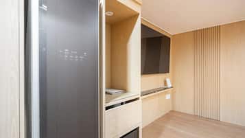 Une cuisine moderne équipée d’un réfrigérateur encastré, d’un four à micro-ondes et d’un petit plan de travail.