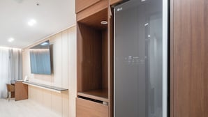 Cocina moderna con refrigerador LG integrado, muebles de madera y encimera con espejo.