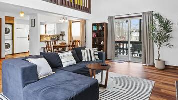 A modern living room with a sofa, a coffee table, and a bookshelf.