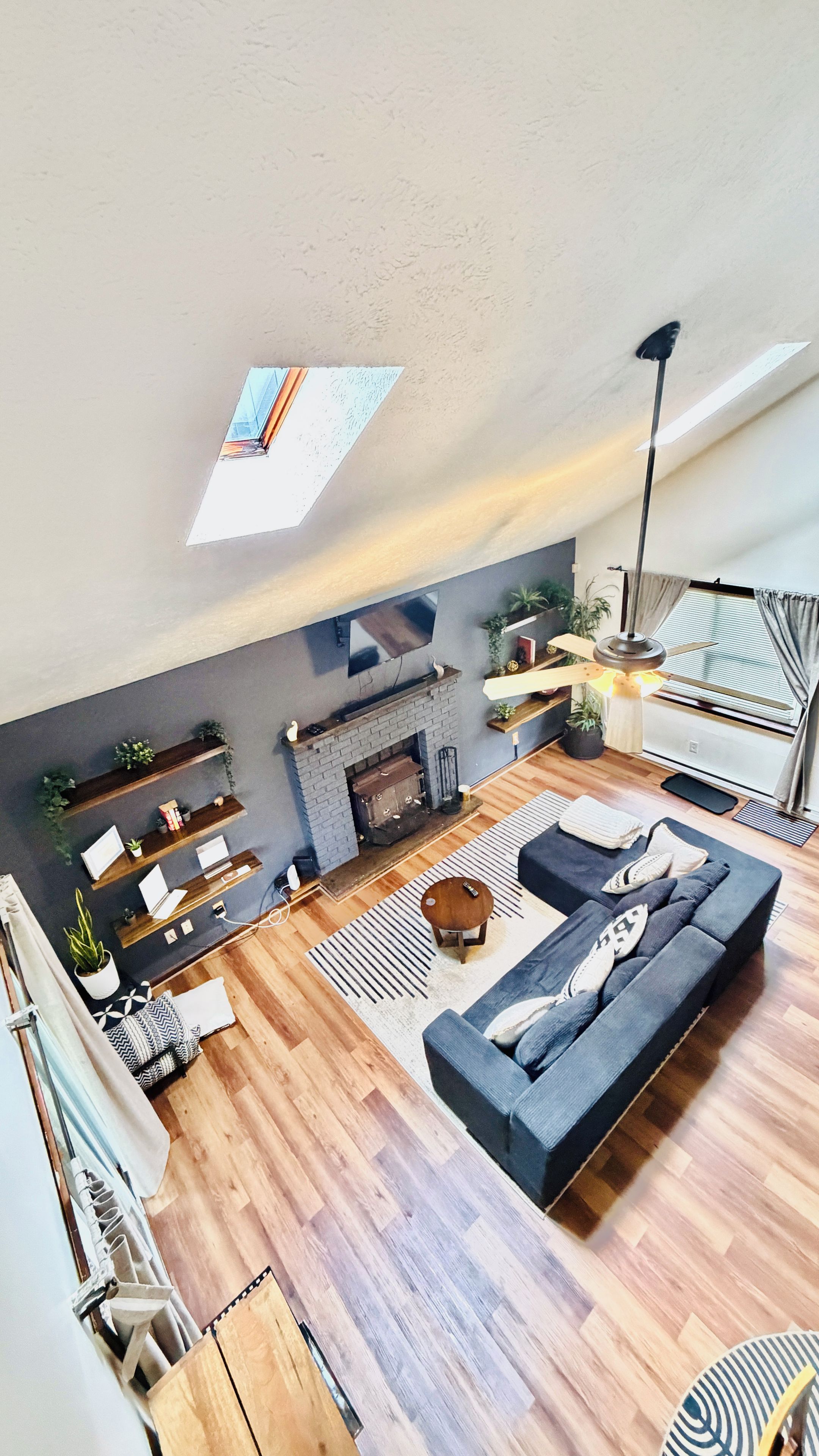 A modern living room with a fireplace, a sofa, a coffee table, and a TV mounted on the wall.
