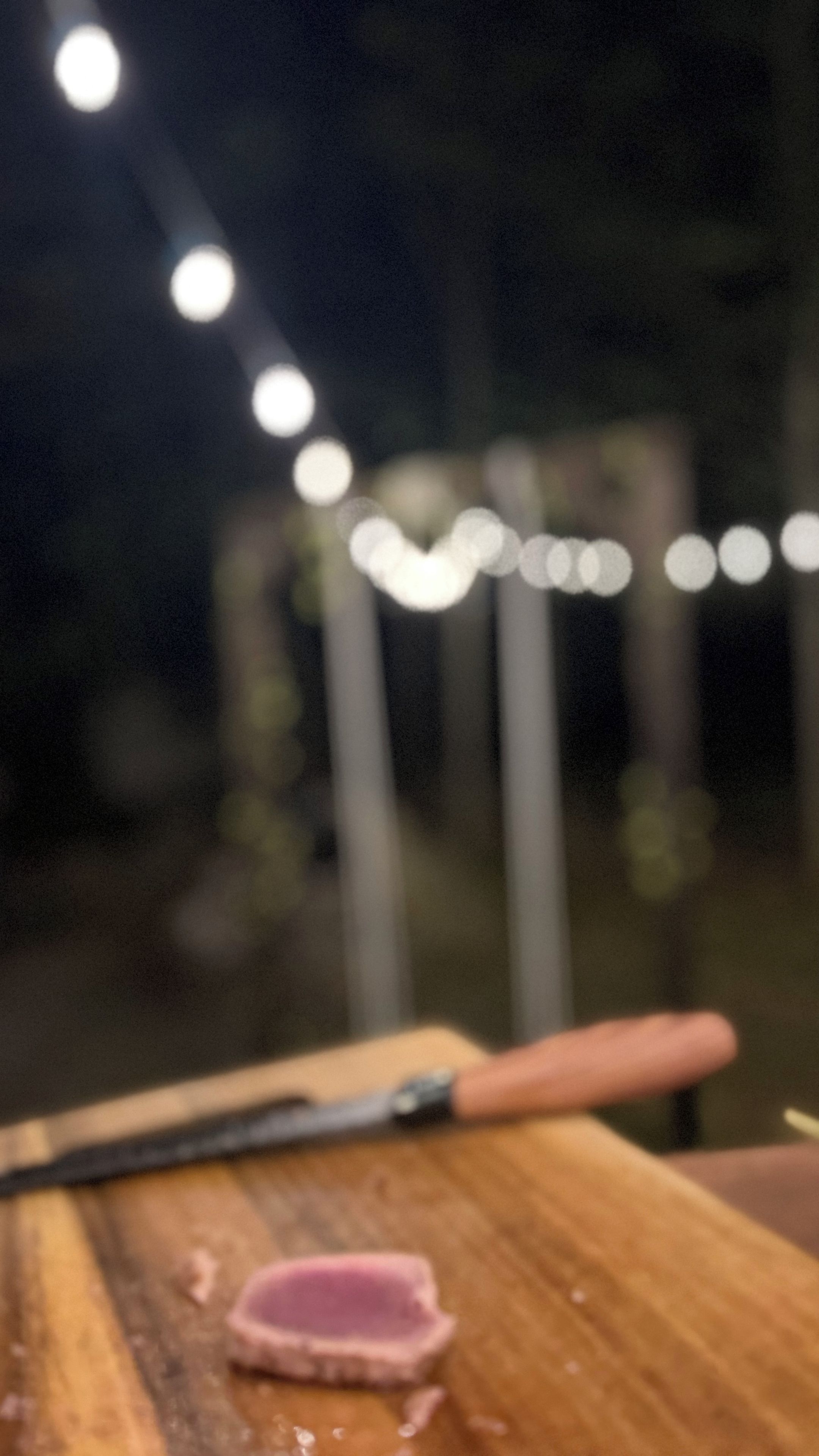 Una superficie de madera con un objeto rosa y un objeto negro.
