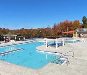 Ein Schwimmbecken mit mehreren Bahnen, einer überdachten Sitzgelegenheit und einem Pavillon.