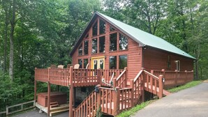 Eine Holzhütte mit Balkon, Treppe und überdachter Veranda.