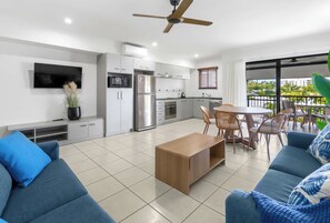 A modern living space with a kitchen, dining area, and seating. - Bluewater Duo—Lagoon Views & Pool by Trinity Beach (Trinity Beach)