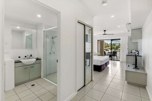 A modern bathroom with a glass-enclosed shower, a large mirror, and a sink. - Bluewater Duo—Lagoon Views & Pool by Trinity Beach (Trinity Beach)
