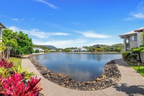 A residential area with a curved water feature, houses, and a clear sky. - Bluewater Duo—Lagoon Views & Pool by Trinity Beach (Trinity Beach)