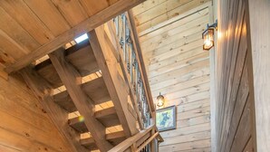 Un escalier en bois avec des rampes en métal et une main courante en bois.