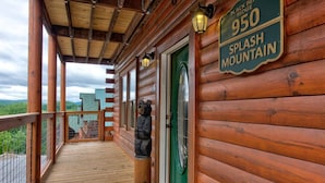 A wooden cabin with a porch, a green door, and a sign reading '950 Splash Mountain.' - Splash Mountain (Sevierville)