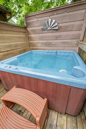 A hot tub with a wooden deck and a bench. - Z - Chalet Morning Pearl (Gatlinburg)