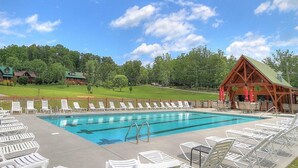 A swimming pool with lounge chairs, a wooden pavilion, and a view of a green landscape. - Big Bear Lodge at Valley View (Sevierville)