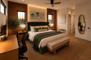 A modern bedroom with a large bed, bedside tables, a desk, and a chair.