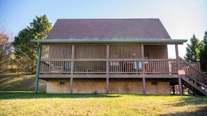 A two-story building with a balcony, a staircase, and a concrete foundation. - Cozy Bear Cove 2 (Pigeon Forge)
