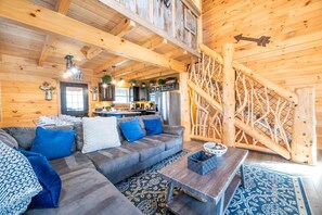 A log cabin interior with a living room, kitchen, and staircase. - Cabin In The Mountains (Sevierville)
