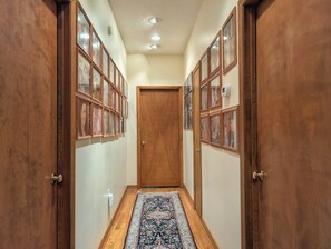 A hallway with wooden doors, a patterned rug, and framed pictures on the walls. - Llyn Blaen House at Lake Junaluska (Lake Junaluska)