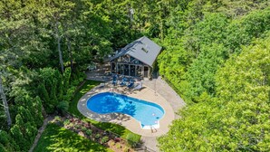 Ein Haus mit Swimmingpool, umgeben von üppigem Grün.