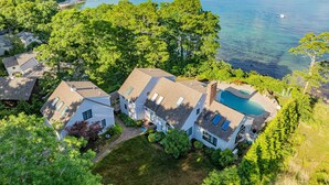Un barrio residencial con casas, una piscina y vistas al mar.