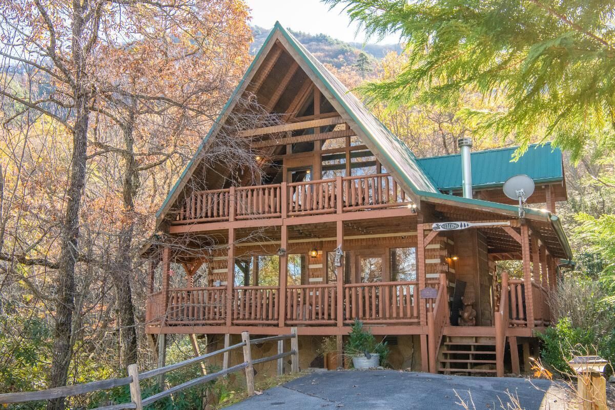 A wooden cabin with a balcony, a satellite dish, and a sign indicating a restaurant.