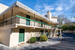A two-story motel with a green door, a covered front porch, and a parking lot. - Roaring Fork Road Retreat (Gatlinburg)
