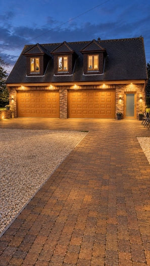 A two-story house with a brick facade, two garage doors, and a gravel driveway. - Surridges Studio, Sleeps 4 w/ Parking & Dogs Ok (Chelmsford)