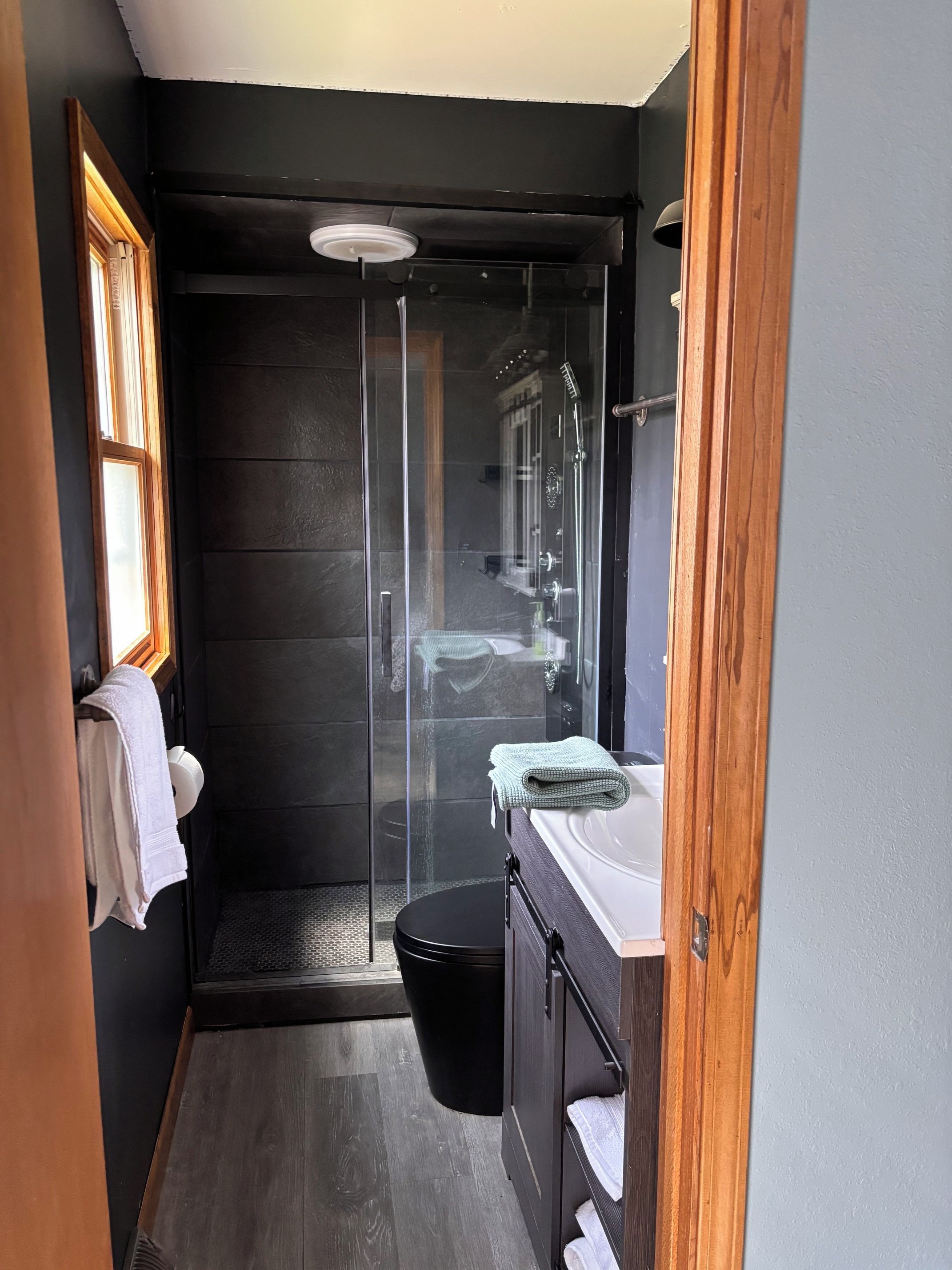 Une salle de bain compacte avec une douche à parois de verre, un lavabo et des toilettes.