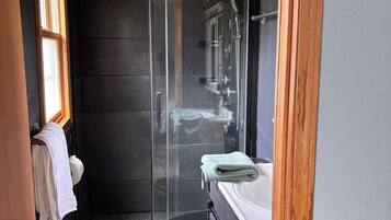 Une salle de bain compacte avec une douche à parois de verre, un lavabo et des toilettes.