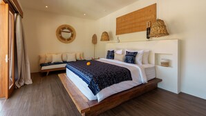 Ein Schlafzimmer mit einem großen Bett, einem Nachttisch, einem Spiegel und einer Pendelleuchte.