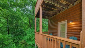 A wooden cabin with a balcony overlooking a forest. - Grizzly Grotto (Sevierville)