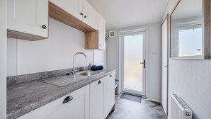 A modern kitchen with white cabinets, a granite countertop, and a built-in sink.