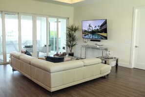 A modern living room with a large sectional sofa, a coffee table, and a flat-screen TV mounted on the wall. - Villa Imperial Bonita Springs 5 minutes to the beach, 4 bed/3 bath (Bonita Springs)