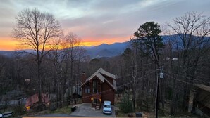 A cabin with a driveway, surrounded by trees and mountains in the background. - Honey Bear Lodge (Gatlinburg)