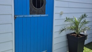 A blue door with a circular window, a potted plant, and a white exterior wall. - A seaside getaway for two in the heart of Fouras (FOURAS)