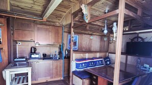 A compact kitchen with wooden cabinets, a sink, and a small table. - A seaside getaway for two in the heart of Fouras (FOURAS)