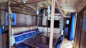 A wooden interior with a long table, benches, and a ceiling fan. - A seaside getaway for two in the heart of Fouras (FOURAS)