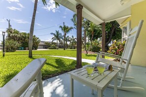 A porch with a table, two chairs, and a drink. - Capecation! A Boater's Paradise, easy & quick out. (Cape Coral)
