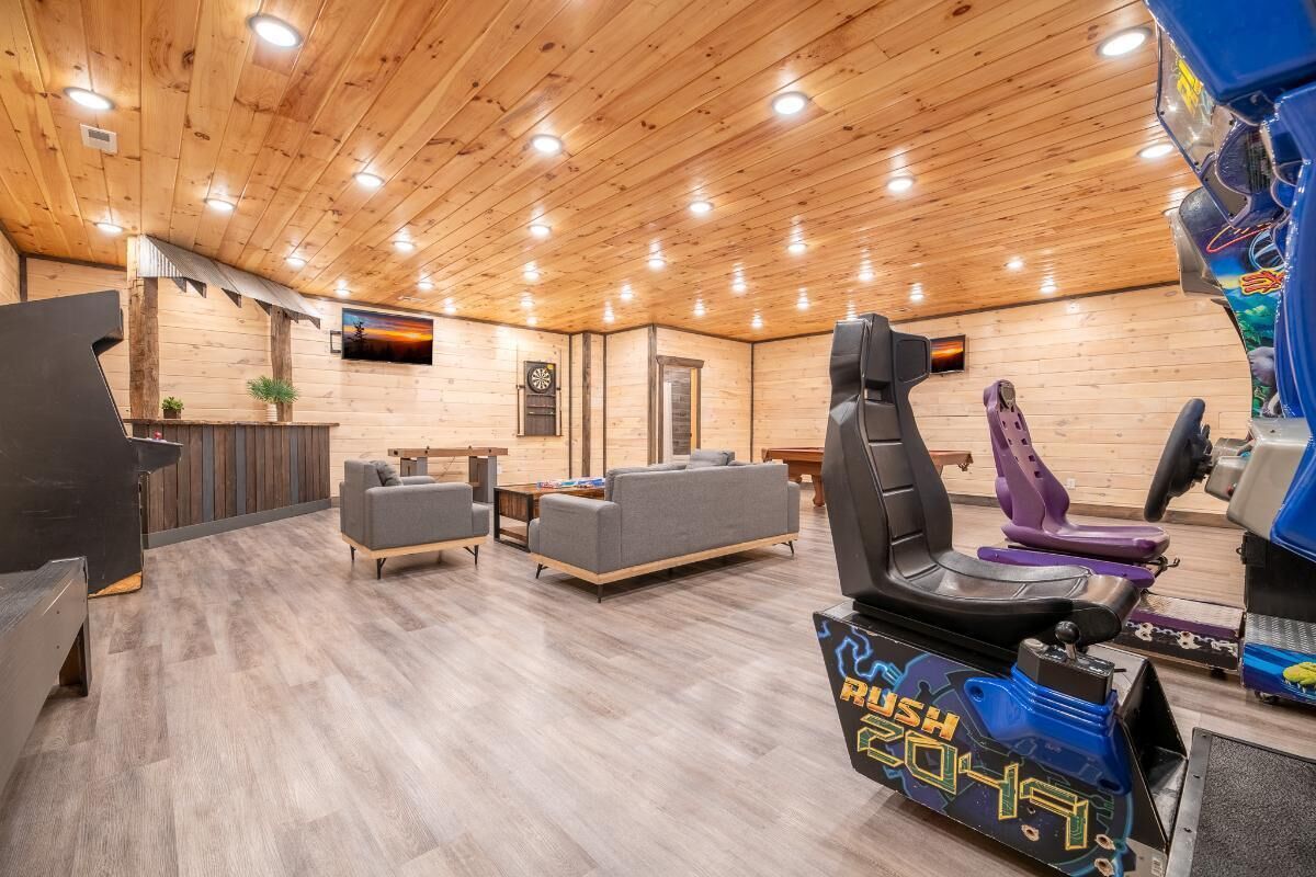 Un intérieur en bois avec une table de ping-pong, des canapés et un espace dédié aux autos tamponneuses.
