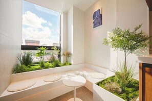 A modern bathroom with a window, a small table, and a bench. - Mumum Jongno (Seoul)