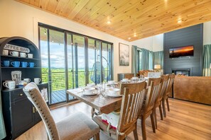 A dining area with a table set for four, a coffee bar, and a fireplace. - Spa Mountain Retreat (Sevierville)
