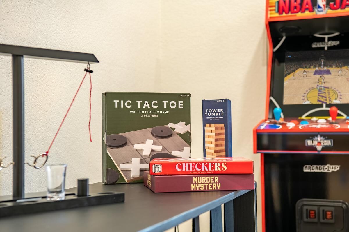 Een tafel met gezelschapsspellen, een damspel, een moordmysterie spel en een toren-tumbler-arcadekast.