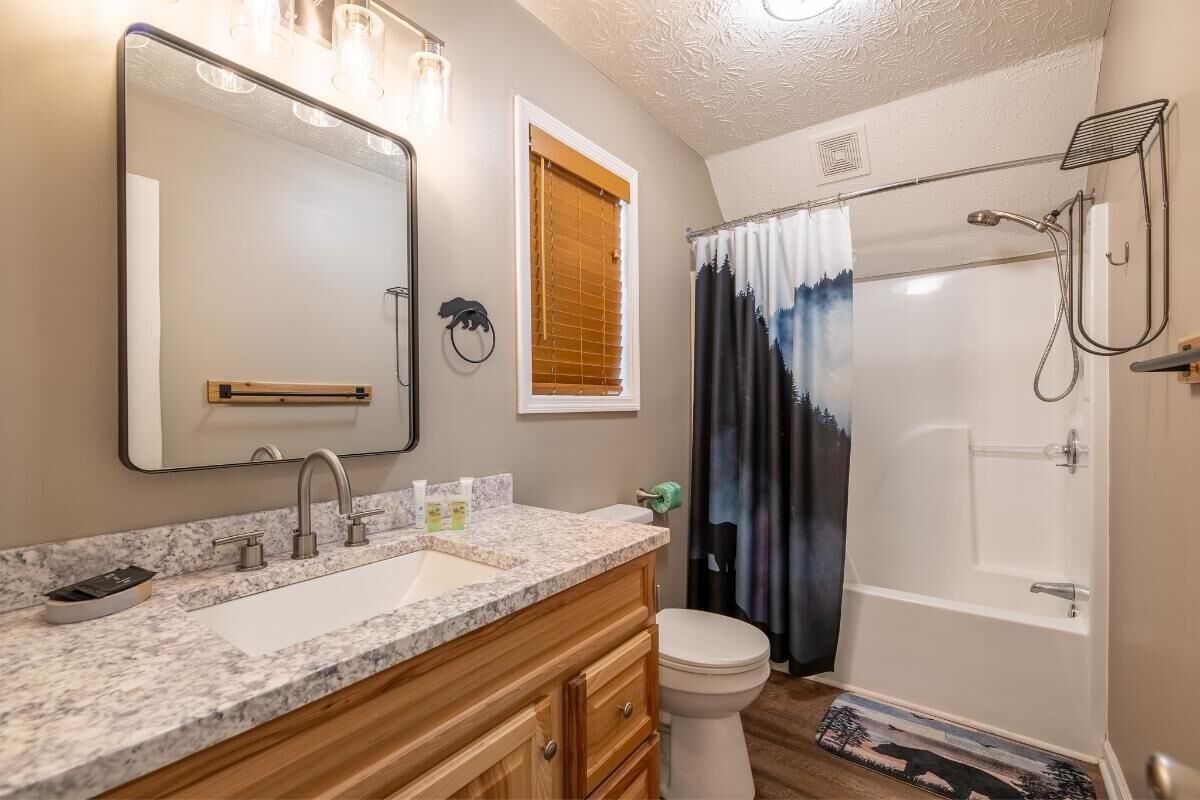 Une salle de bain avec deux éviers, des toilettes, une baignoire et une douche.
