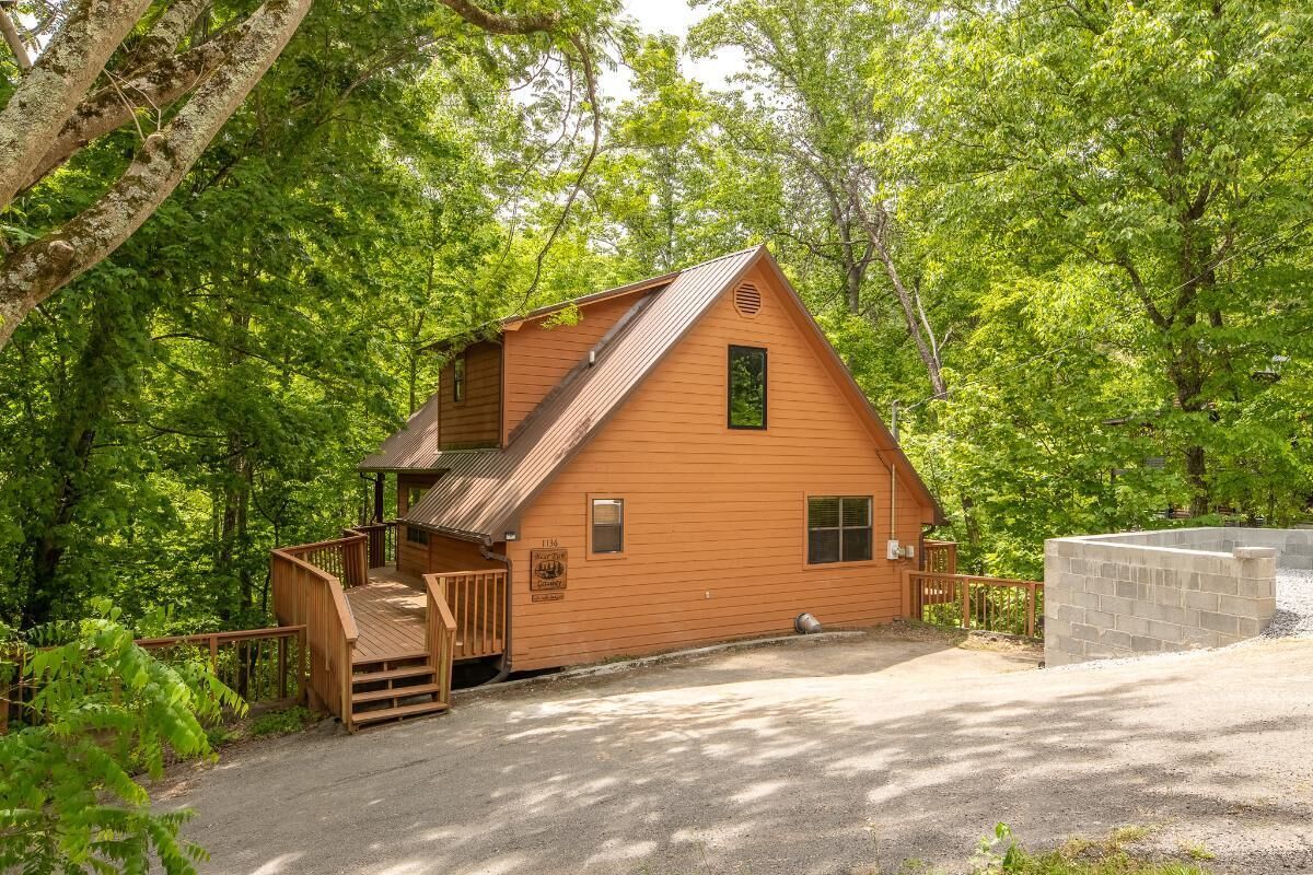 A cabin with a wooden exterior, a porch, and a small deck.