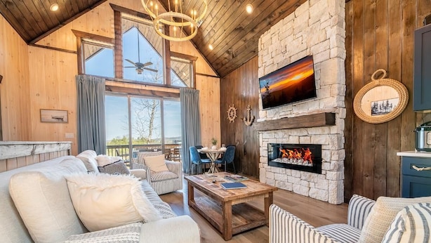 Interior acogedor de una cabaña con chimenea de piedra, paredes de madera y un comedor.