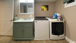 A laundry area with a washer and dryer, a sink, and a mirror. - Close to the Causeway! (Naples)