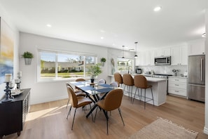 A modern kitchen with white cabinets, stainless steel appliances, and a large island. - Luxury 3BR Retreat | Hot Tub, Fire Pit & Games (Simi Valley)