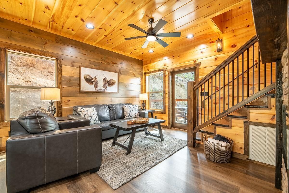 Un intérieur en bois avec un canapé, une table basse et un escalier.