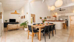 Une cuisine moderne avec un coin repas, comprenant une table en bois, des chaises et un téléviseur.